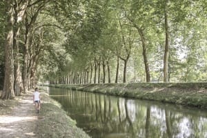 Petite fille qui se balade le long du canal doux et ombragé de la Sauldre