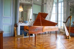 Le salon de musique avec le piano et la harpe au milieu du château